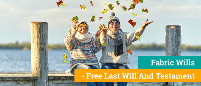 Couple with knit sweaters and hats sit on a dock throwing leaves 
